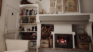A cozy living room with a fireplace, bookshelves, and decorative items.