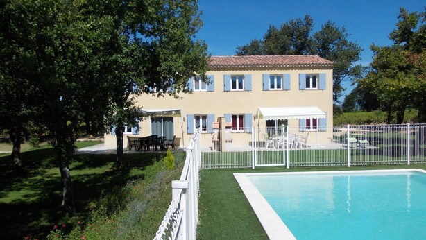 Un hotel con piscina, area salotto all'aperto e giardino.