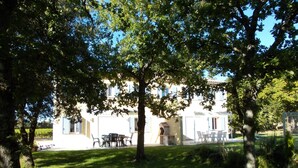 Un edificio bianco con un patio, circondato da alberi.