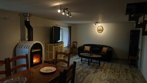 A cozy living room with a fireplace, a television, and a sofa.