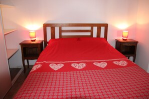 A bed with a red bedspread and heart patterns, flanked by two bedside tables with lamps. - CHARMING CHALET HAUTES VOSGES (Saulxures-sur-Moselotte)