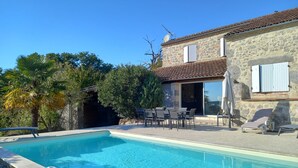 A swimming pool with a stone house in the background. - Rental in Nerac en Albret, stone built house, detached, renovated. (Nérac)