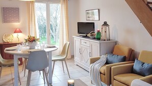 A cozy living room with a dining area, a staircase, and a TV. - House with garden by the sea in Pornic. Nearby beach. (Pornic)