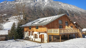 A wooden chalet with a balcony, set against a snowy mountain backdrop. - Chalet Jamoo, an authentic renovated farmhouse in the heart of the Aravis mountains  (Entremont)