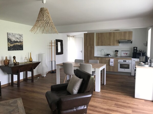 A modern living room with a dining area and a kitchen.