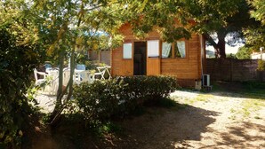 Eine Holzhütte mit Tür, Fenstern und einer kleinen Veranda.