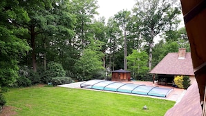 A backyard with a swimming pool, a wooden deck, and a small shed. - Norman house with pool in the countryside (Bâlines)