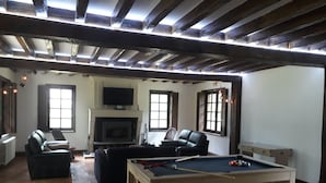 A spacious living room with a pool table, a fireplace, and a television mounted on the wall. - Norman house with pool in the countryside (Bâlines)