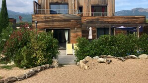 A modern two-story building with a wooden facade, large windows, and a balcony.