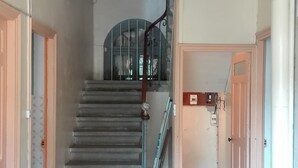 A staircase with a patterned carpet leading to a landing. - Large family house sleeps 16 in the heart of a beautiful medieval village (Génolhac)