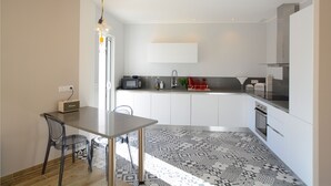 A modern kitchen with white cabinets, a black countertop, and a patterned floor. - New villa with swimming pool overlooking a hectare of land overlooking the vineyard (Patrimonio)