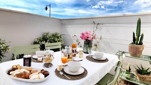 A table set for breakfast with pastries, drinks, and a cactus plant.