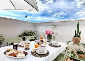 A table set for breakfast with pastries, drinks, and a cactus plant.