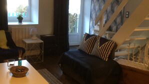 A cozy room with a bed, a small table, a lamp, and a window with curtains.