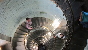 A spiral staircase with a circular design, metal railings, and a central open area.