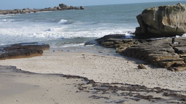 A rocky beach with waves crashing onto the shore.