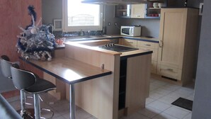 A compact kitchen with a central island, a microwave, and a refrigerator.