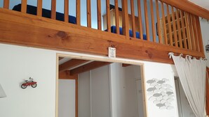 A wooden staircase with a view of a room above. - quiet house in the heart of the pine forest in pedestrian area. Near beaches (Lacanau)