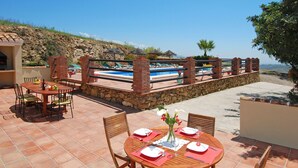 A patio with a pool, dining area, and a barbecue setup. - Villa Poyatos, 15 people, Heated Pool, Wifi, BBQ, Petfriendly, sea view (Comares)