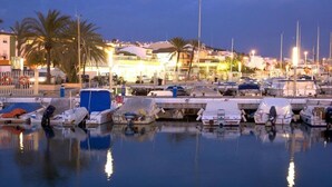 A marina with boats docked, palm trees, and buildings in the background. - Villa Poyatos, 15 people, Heated Pool, Wifi, BBQ, Petfriendly, sea view (Comares)