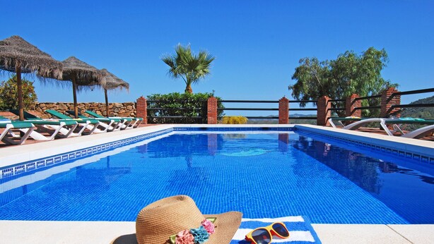 A swimming pool with lounge chairs and a straw hat with sunglasses on a towel. - Villa Poyatos, 15 people, Heated Pool, Wifi, BBQ, Petfriendly, sea view (Comares)