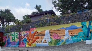 A colorful mural on a wall with a waterfall and tropical plants. - Chalet Filaos 2*, sea view, near Saint-Leu and its beaches  (Saint-Leu)