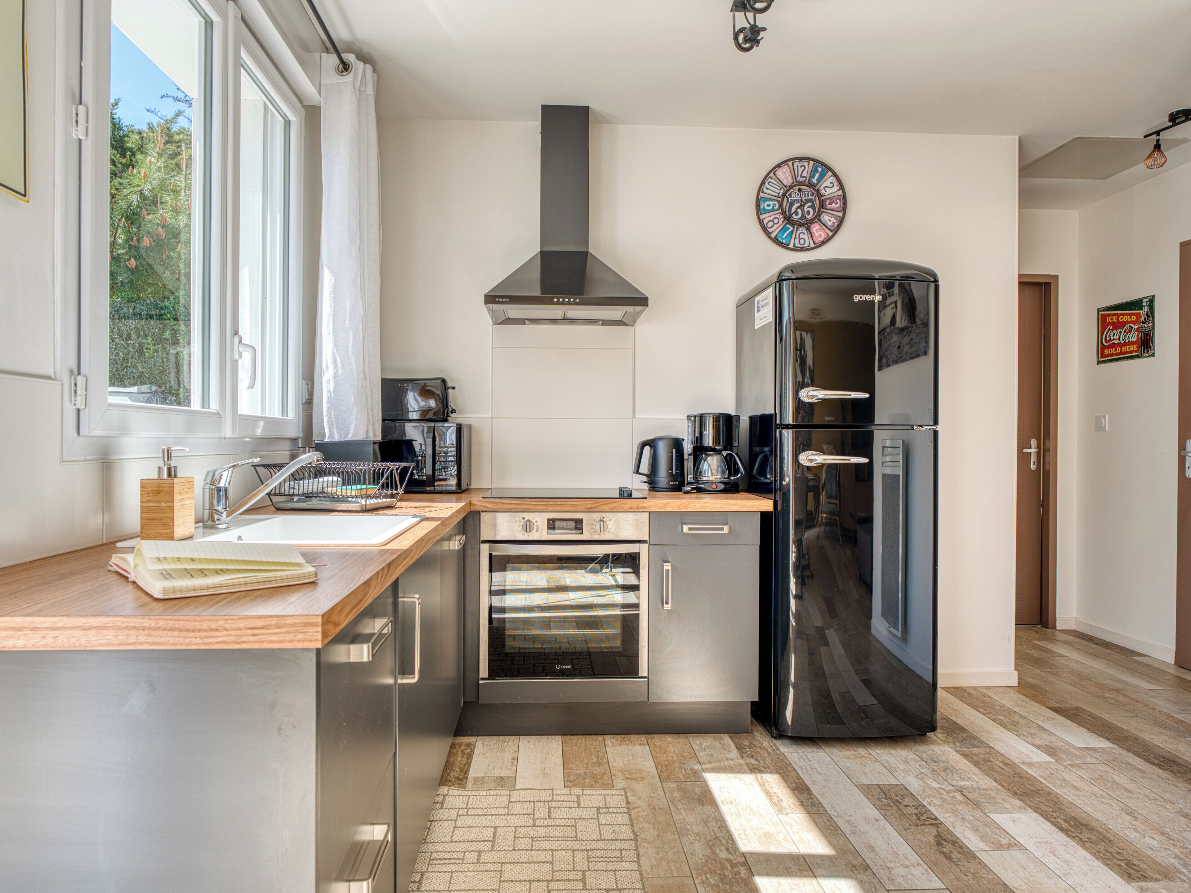 Eine moderne Küche mit Backofen, Kaffeemaschine und Kühlschrank.