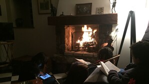 Un accogliente soggiorno con camino, televisore e un tavolo con un bicchiere e un piatto.