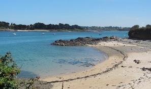 A beach with clear blue water, boats, and rocky outcrops. - Fisherman's house for rent, sea view, Brittany (Plougrescant)