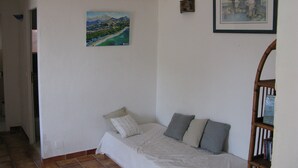 A bedroom with a bed, pillows, a painting, and a bookshelf. - PROMOTION! A charming villa with a beautiful garden and a view of the mountains (Calenzana)