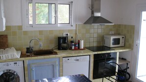 A compact kitchen with a washing machine, dishwasher, microwave, and a coffee maker. - PROMOTION! A charming villa with a beautiful garden and a view of the mountains (Calenzana)
