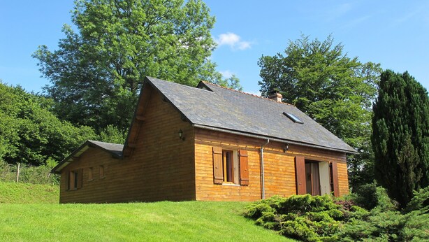 Eine kleine Holzhütte mit geneigtem Dach, Schornstein und Fenster.