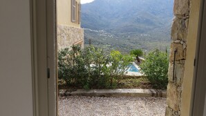 Blick von einem Balkon auf einen Pool und Berge.