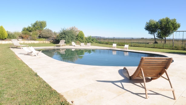 A swimming pool with lounge chairs and a grassy area. - ----------- (Marseillan)