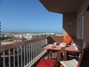 A balcony with a table, chairs, and a view of the city and sea. - Apartment in downtown FARO offering comfortable and Beautiful Views (Faro)