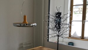 Un coin repas avec une table en bois, une assiette bleue, un classeur vert et une chaise noire.