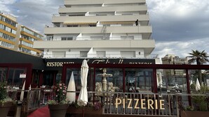 Een modern gebouw met een pizzeria op de begane grond.