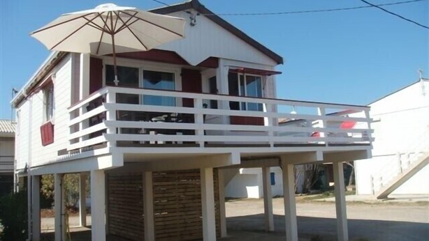 Een gebouw met twee verdiepingen, een balkon en een parasol.