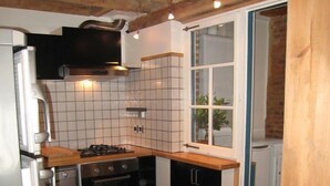 Una cocina compacta con piso a cuadros, una estufa y un refrigerador.
