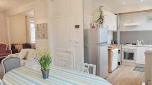 A modern kitchen with stainless steel appliances, a dining area with striped tablecloths, and a cozy living space with striped chairs. - From 98€/jour, 5mns walk to fine sand at M Basse, Jard, 7pers+BB, heating included (Veules-Les-Roses)