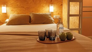 A wooden room with a bed, pillows, a bottle, glasses, and apples on a tray. - The Loft House Barcelona (Barcelona)
