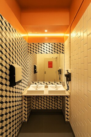 A restroom with a geometric patterned wall, two sinks, a mirror, and a red sign on the door. - The Loft House Barcelona (Barcelona)