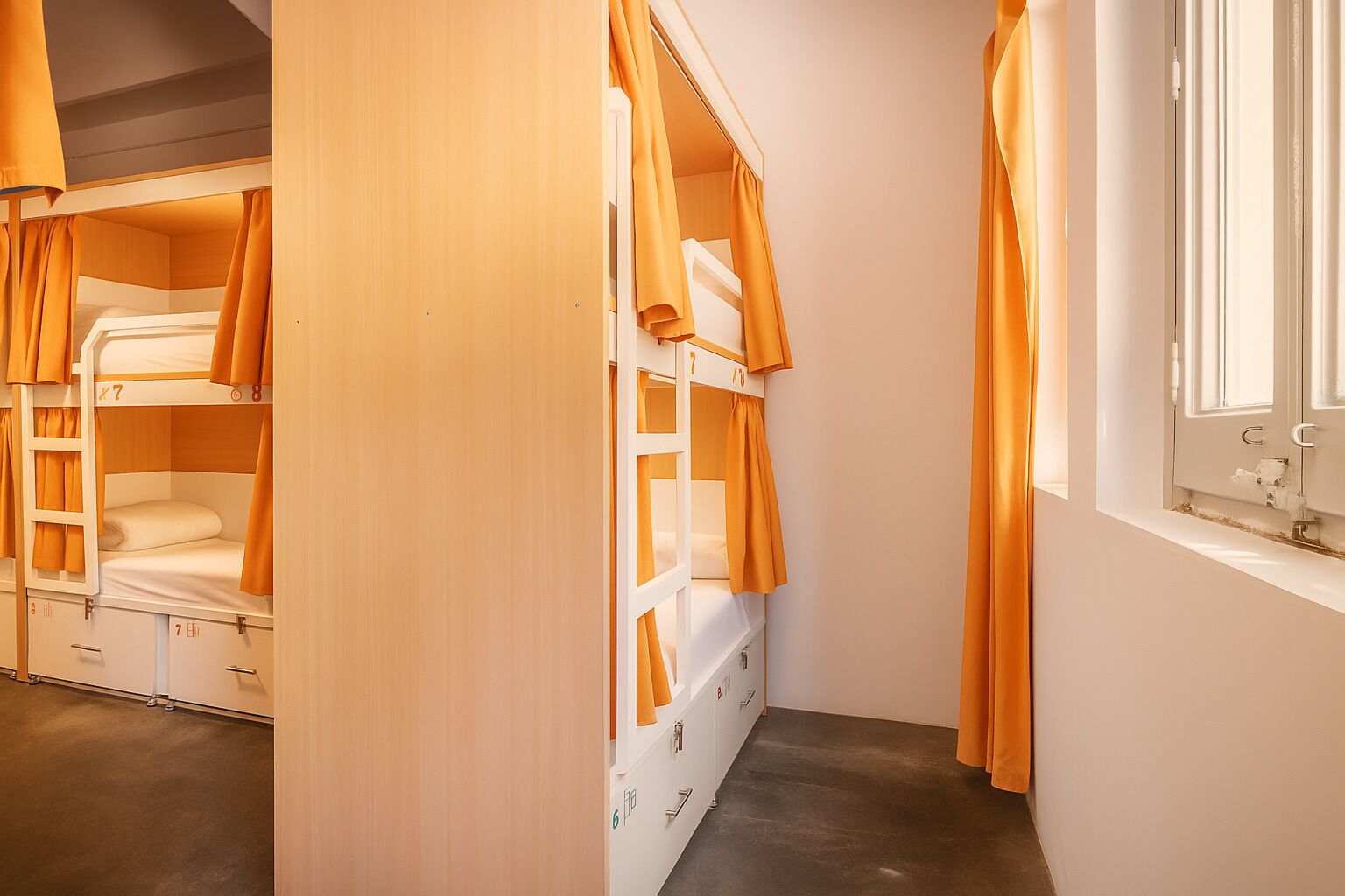 A room with bunk beds, a window, and a door.