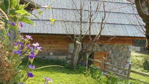 Ein rustikales Steinhaus mit Holztür und Metalldach.