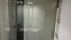 A modern bathroom with a glass-enclosed shower, a white toilet, and a black bathtub. - Nice triplex with balcony and mountain view, near ski- WIFI ACCESS (Saint-Lary-Soulan)