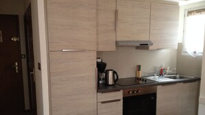 A compact kitchen with light wood cabinets, a stainless steel sink, and a built-in oven. - Nice triplex with balcony and mountain view, near ski- WIFI ACCESS (Saint-Lary-Soulan)