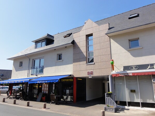 A building with a blue awning, a sign for 'EMPOTER', and a 'CREPERIE' sign.