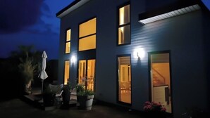 A modern two-story house with large windows and a well-lit interior. - Bright house with garden and spa, 100 m from the beach. Pets welcome. (Plouguerneau)