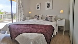 A modern bedroom with a large bed, two bedside tables, a window with curtains, and two framed pictures on the wall. - Large 4P Pointe Croisette Huge terrace Sea view Beaches Wifi Air conditioning Garage (Cannes)