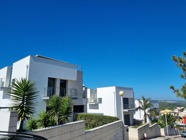 A modern residential building with a flat roof, large windows, and a balcony. - Villa d'ARCHITECTE, Sur les hauteurs, VUE MER, calme, TERRASSE 360°. (casal mota)